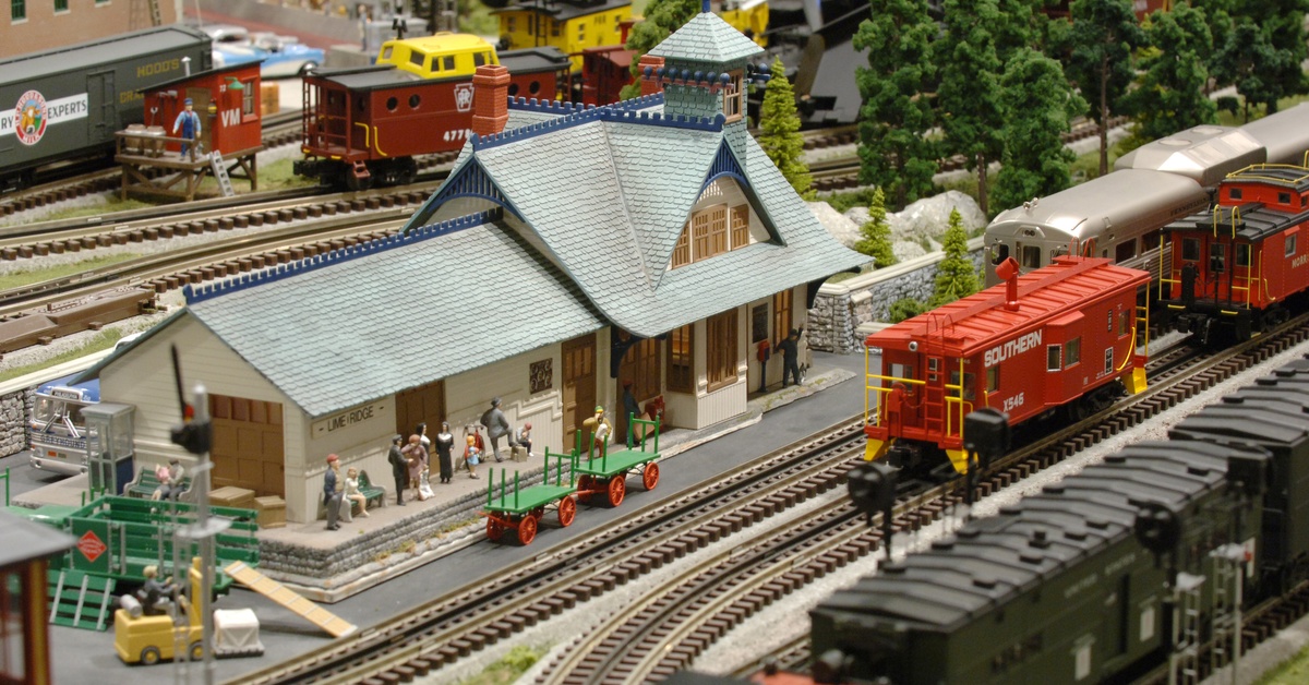 A model of a large, sprawling trainyard. There are multiple trains on different tracks going in different directions.
